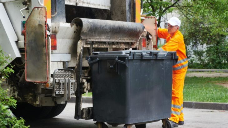 popelář a vyprázdněná popelnice u auta