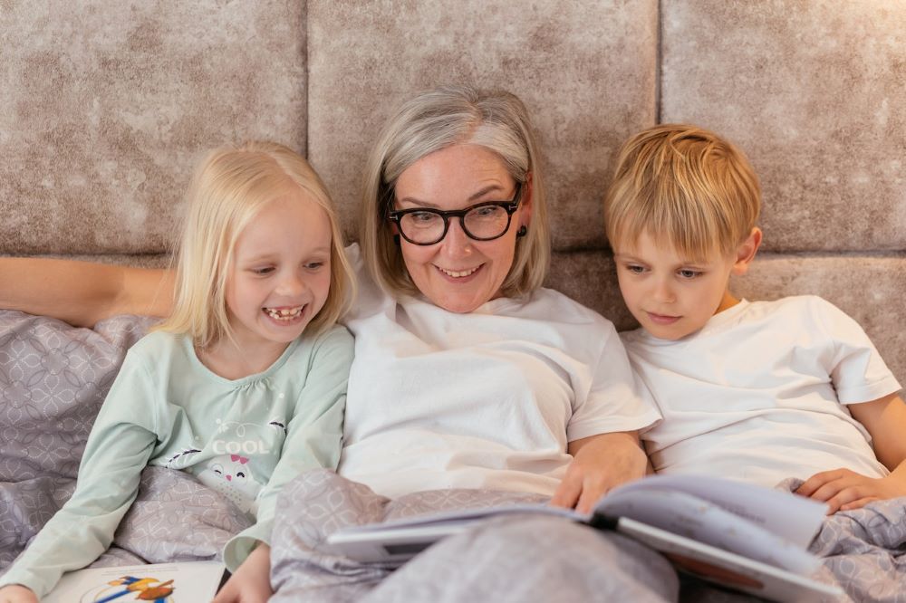 babička čte v posteli svým vnoučatům