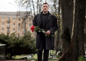 muž s kyticí na hřbitově