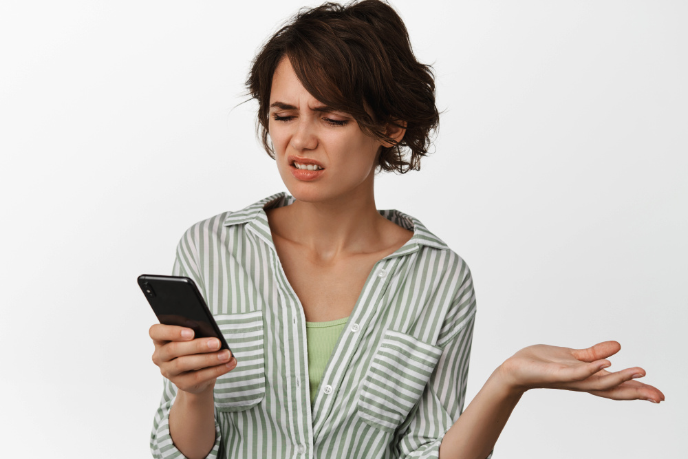 Naštvaná žena kouká na mobil