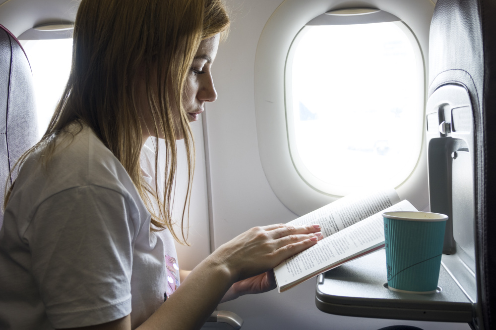 Žena si čte v letadle