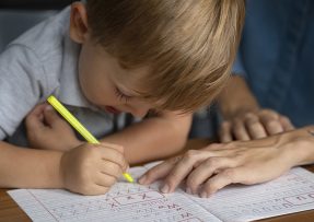 Malý chlapec se učí psát písmena