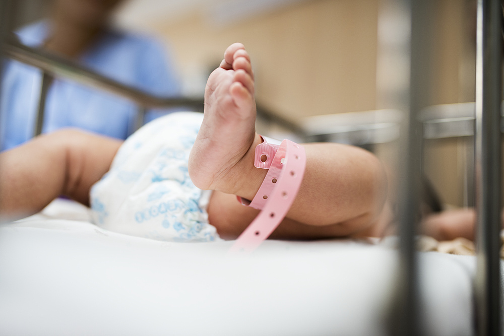 Nožička novorozence v postýlce v nemocnici