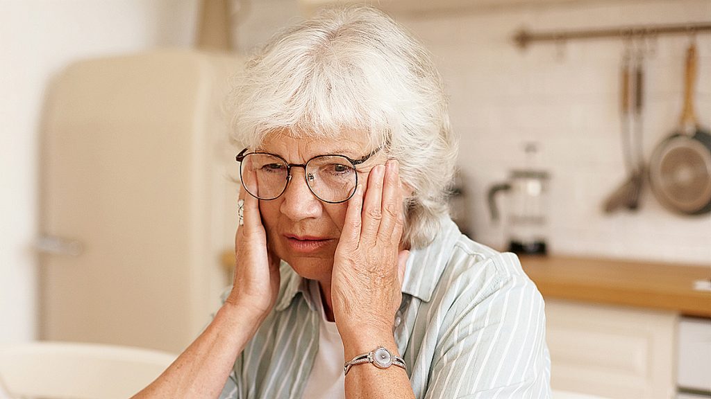 Starí žena má hkavu v dlaních