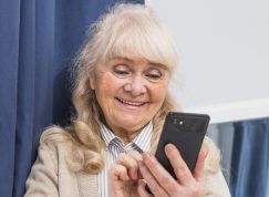 Usměvavá seniorka s mobilem