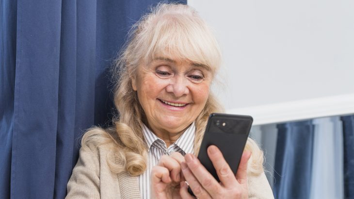 Usměvavá seniorka s mobilem