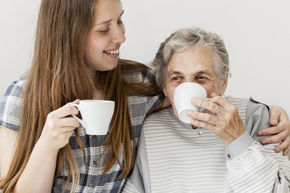 Vnučka s babičkou popíjí kávu