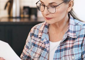 Žena v brýlích čte dopis