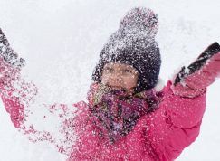 Malá dívka hází sníh