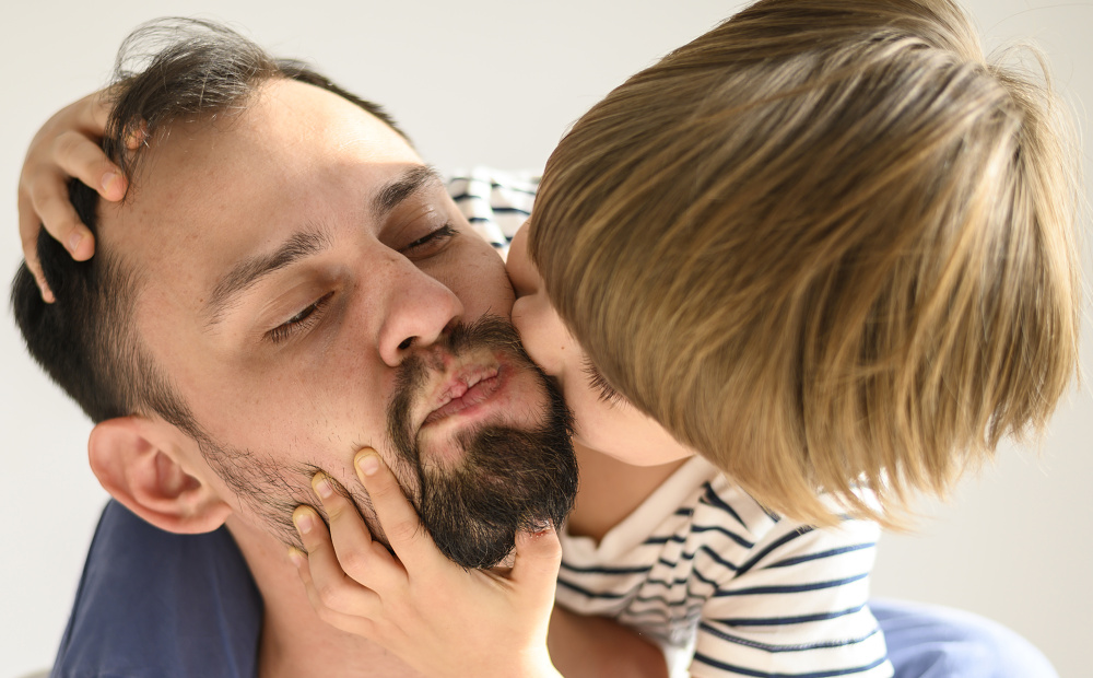 Malý chlapec dává pusu otci