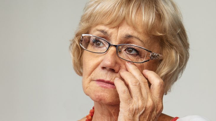 Smutná starší žena s brýlemi
