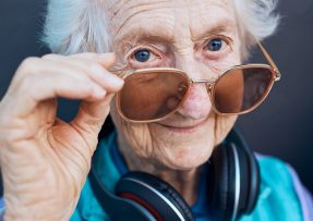 Seniorka s brýlemi a sluchátky