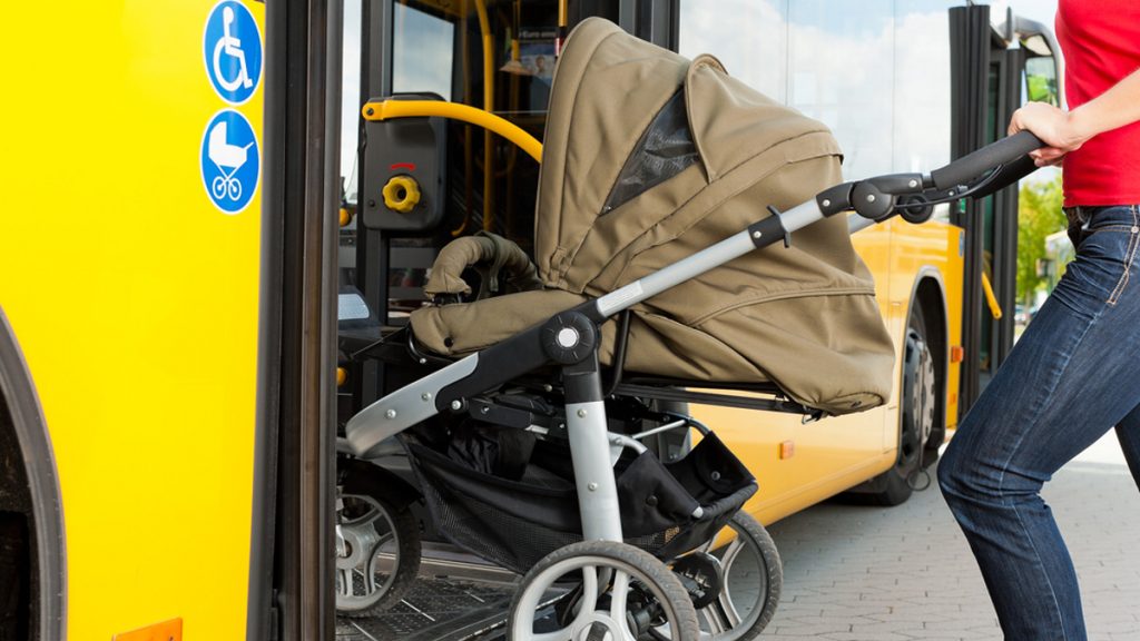 Žena s kočárkem nastupuje do autobusu