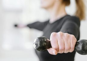 Ženská ruka drží činku