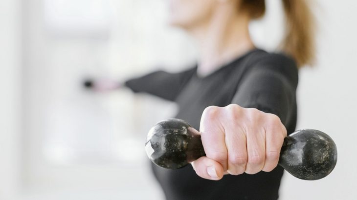 Ženská ruka drží činku