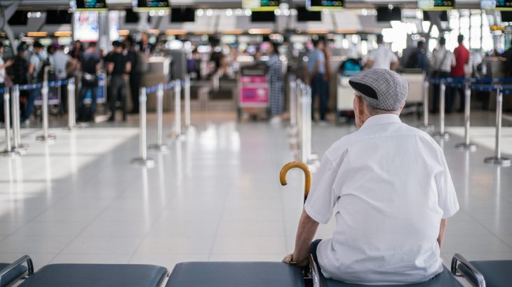 Starý muž sedí na letišti