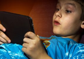 Chlapec sleduje film na tabletu