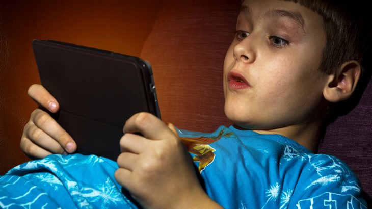 Chlapec sleduje film na tabletu