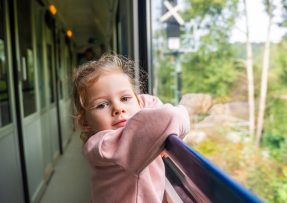 Holčička ve vlaku kouká z okna