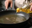 Kuchař leje olej na pánev