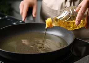 Kuchař leje olej na pánev