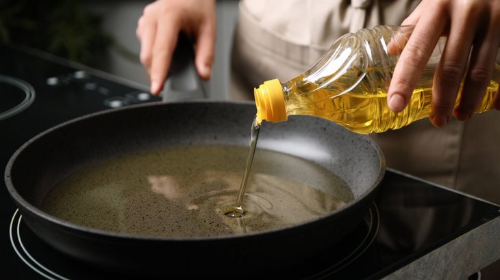 Kuchař leje olej na pánev