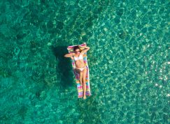 Žena na matračce na moři