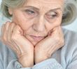 Smutná seniorka s hlavou v dlaních