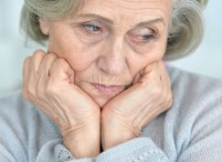 Smutná seniorka s hlavou v dlaních