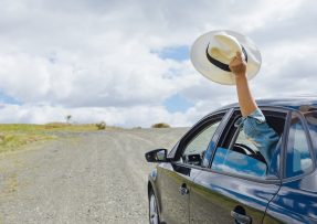 Jedoucí auto a ruka s kloboukem