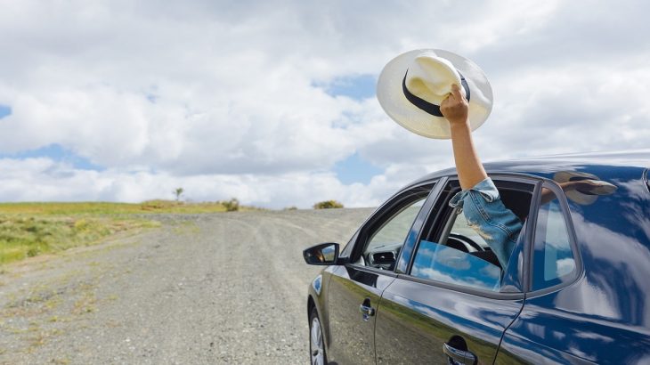 Jedoucí auto a ruka s kloboukem