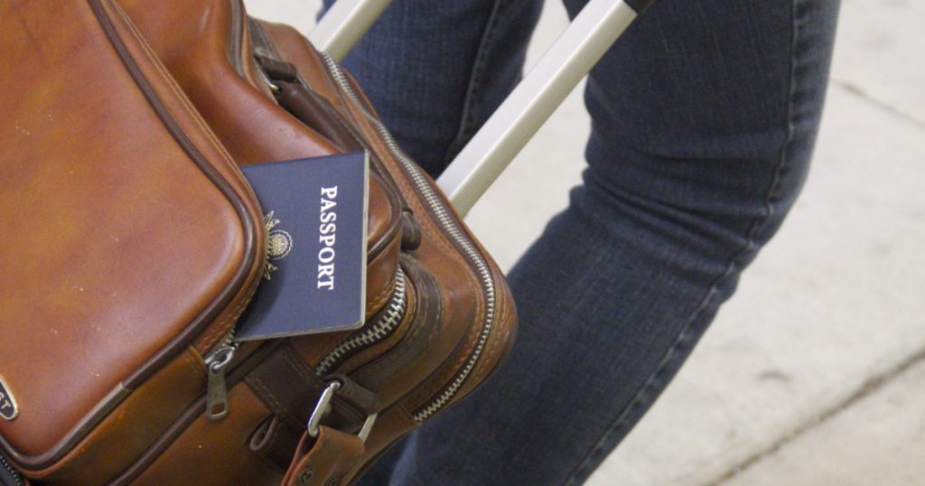 Cestující osoba s kufrem a pasem